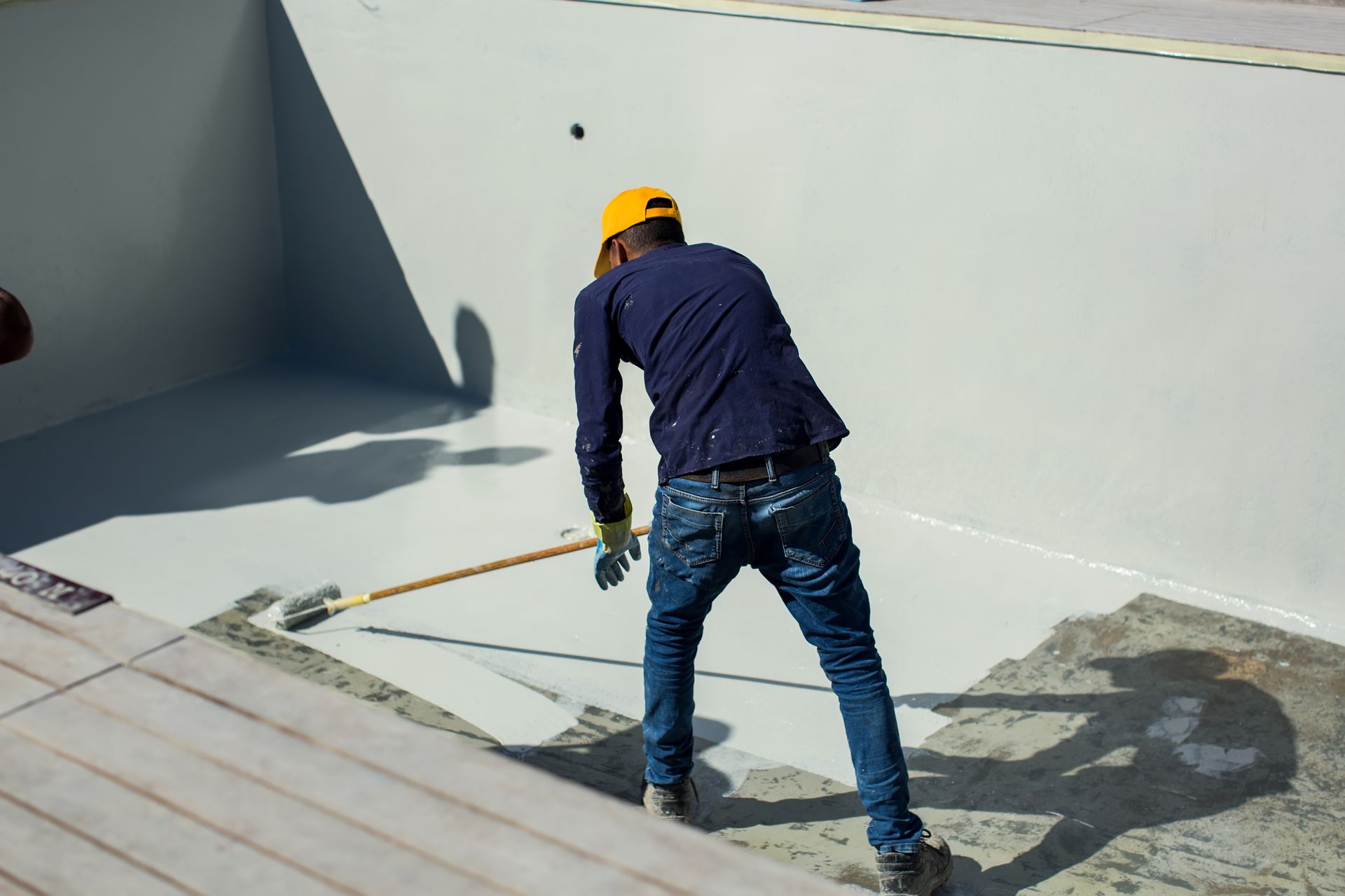 Applying epoxy paint on a surface of a pool. Pool reconsrtuction concept.