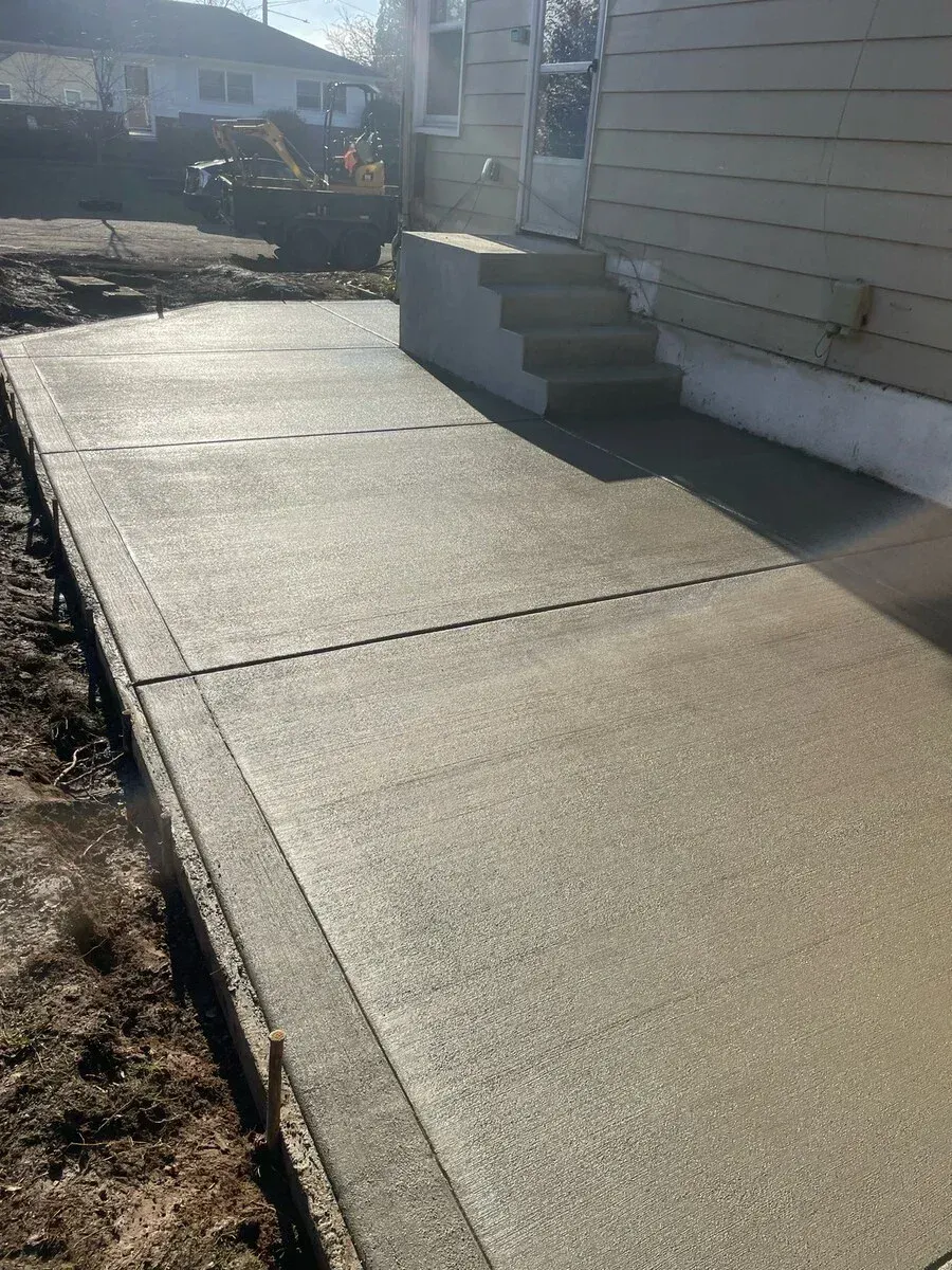 A concrete walkway is being built in front of a house.