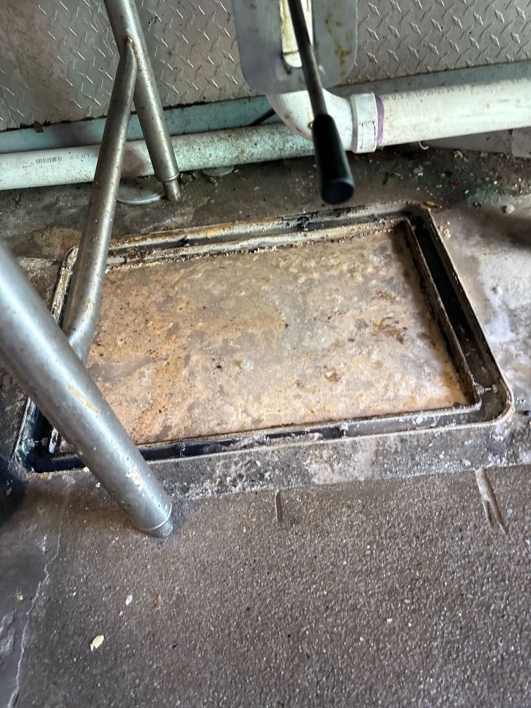 Close-up of a metal grate with heavy rust on the right side, a clean left side, and a vertical metal strip.