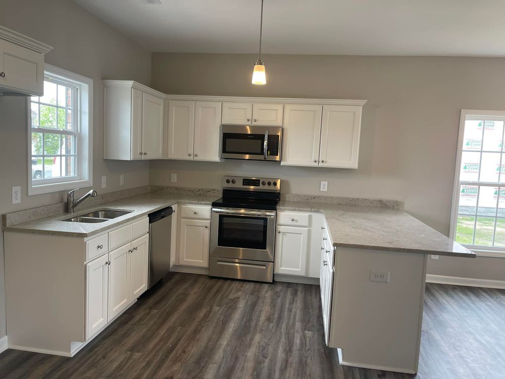 A kitchen with white cabinets and stainless steel appliances.