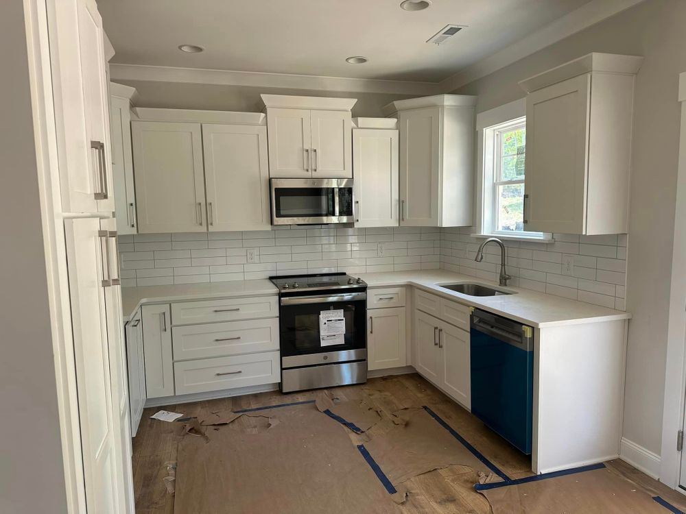A kitchen with white cabinets and stainless steel appliances