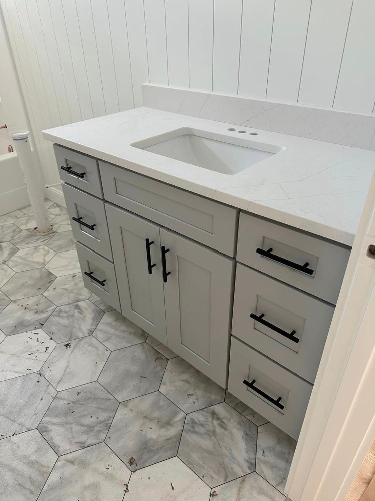 A bathroom with a sink , cabinets and drawers.