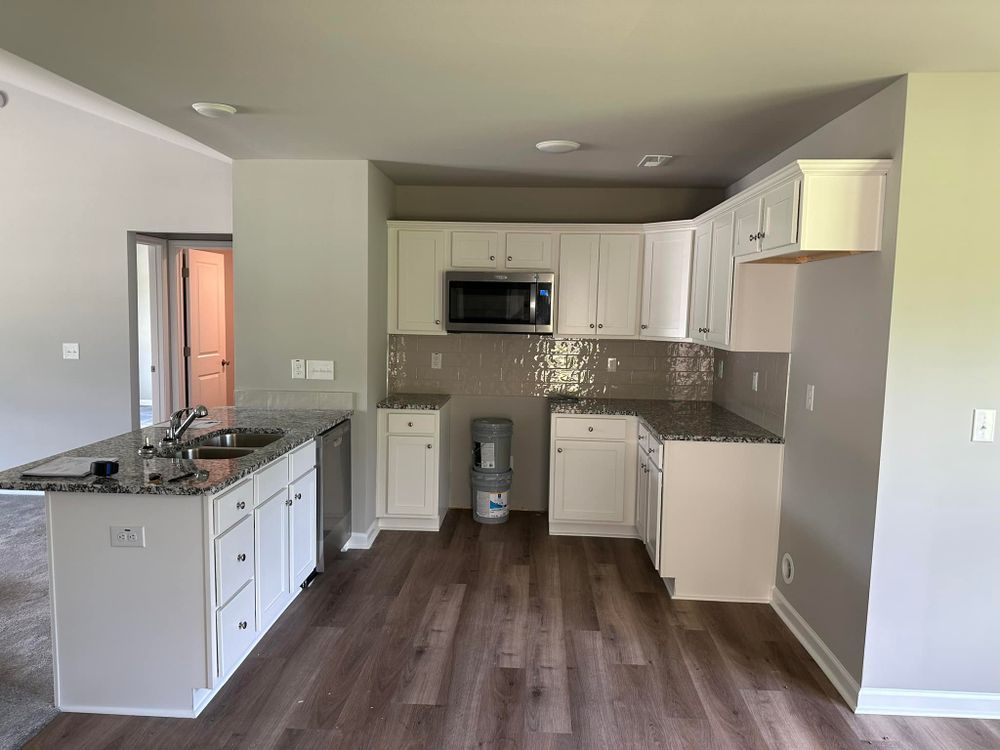 A kitchen with white cabinets and granite counter tops