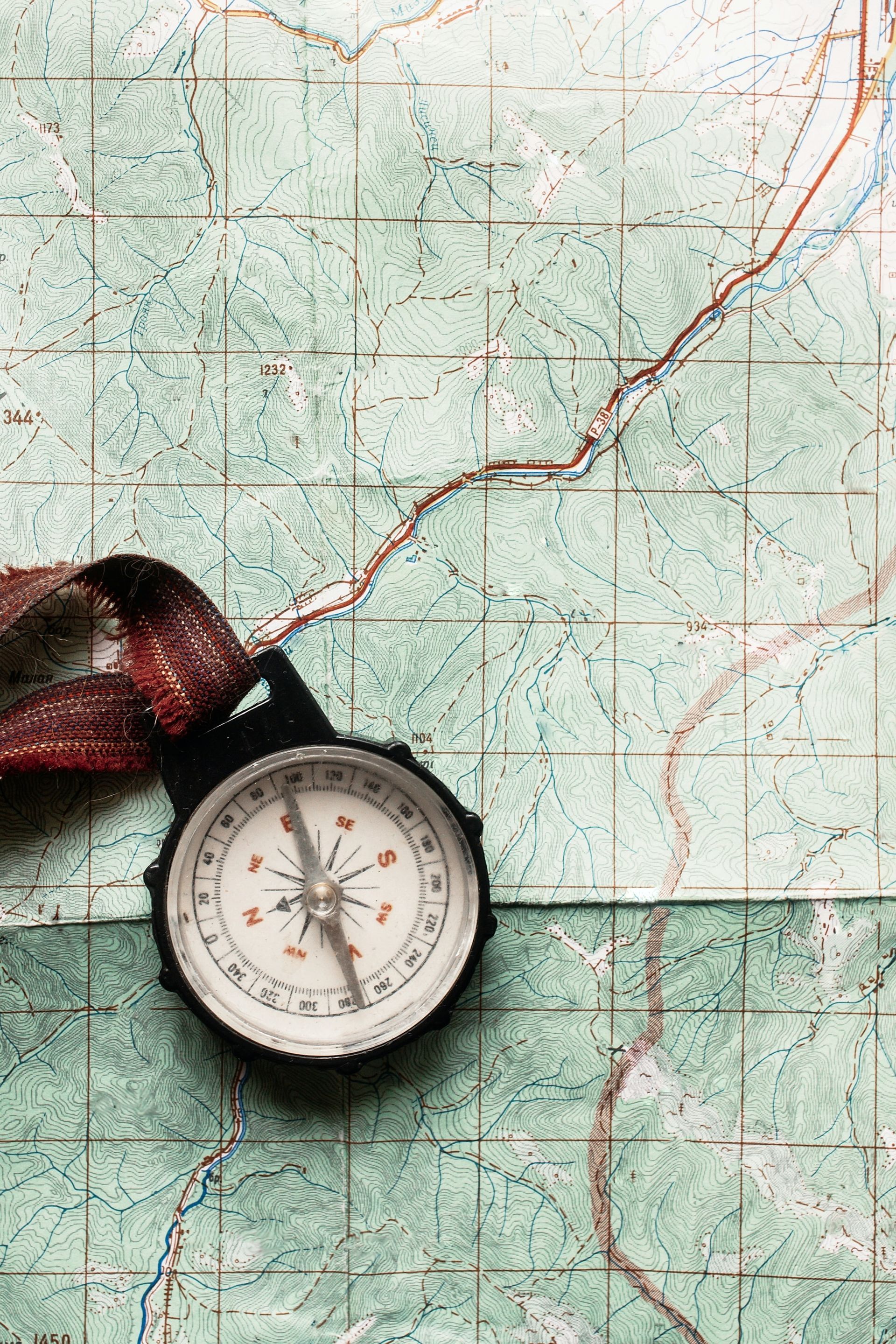 A compass is sitting on top of a map.