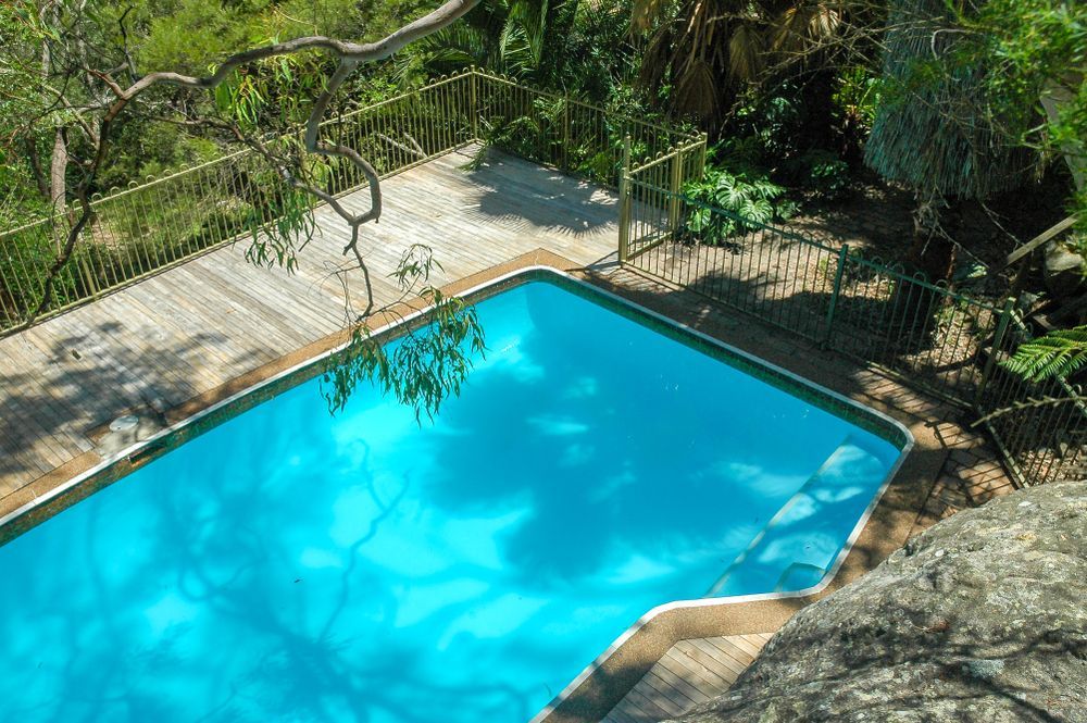 A Swimming Pool Surrounded by a Wooden Deck — A Betta Fence 'N' Yard In Port Macquarie, NSW