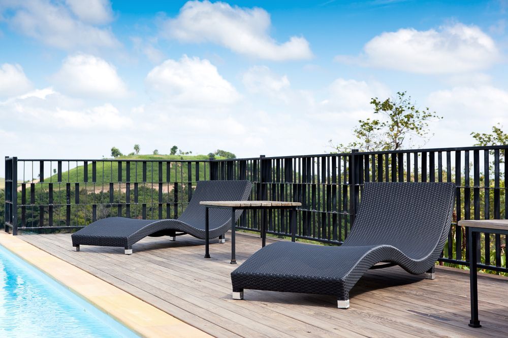 Two Black Lounge Chairs on a Wooden Deck — A Betta Fence 'N' Yard In Port Macquarie, NSW