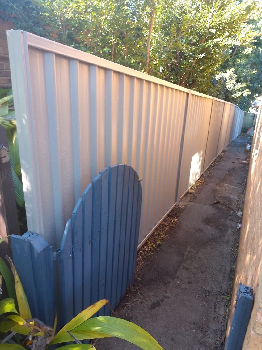 A Light-coloured Corrugated Metal Fence Runs — A Betta Fence 'N' Yard In Wauchope, NSW