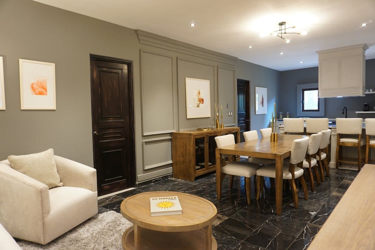 Modern living-dining room with beige sofa, round coffee table, and dining area with a wooden table and chairs.