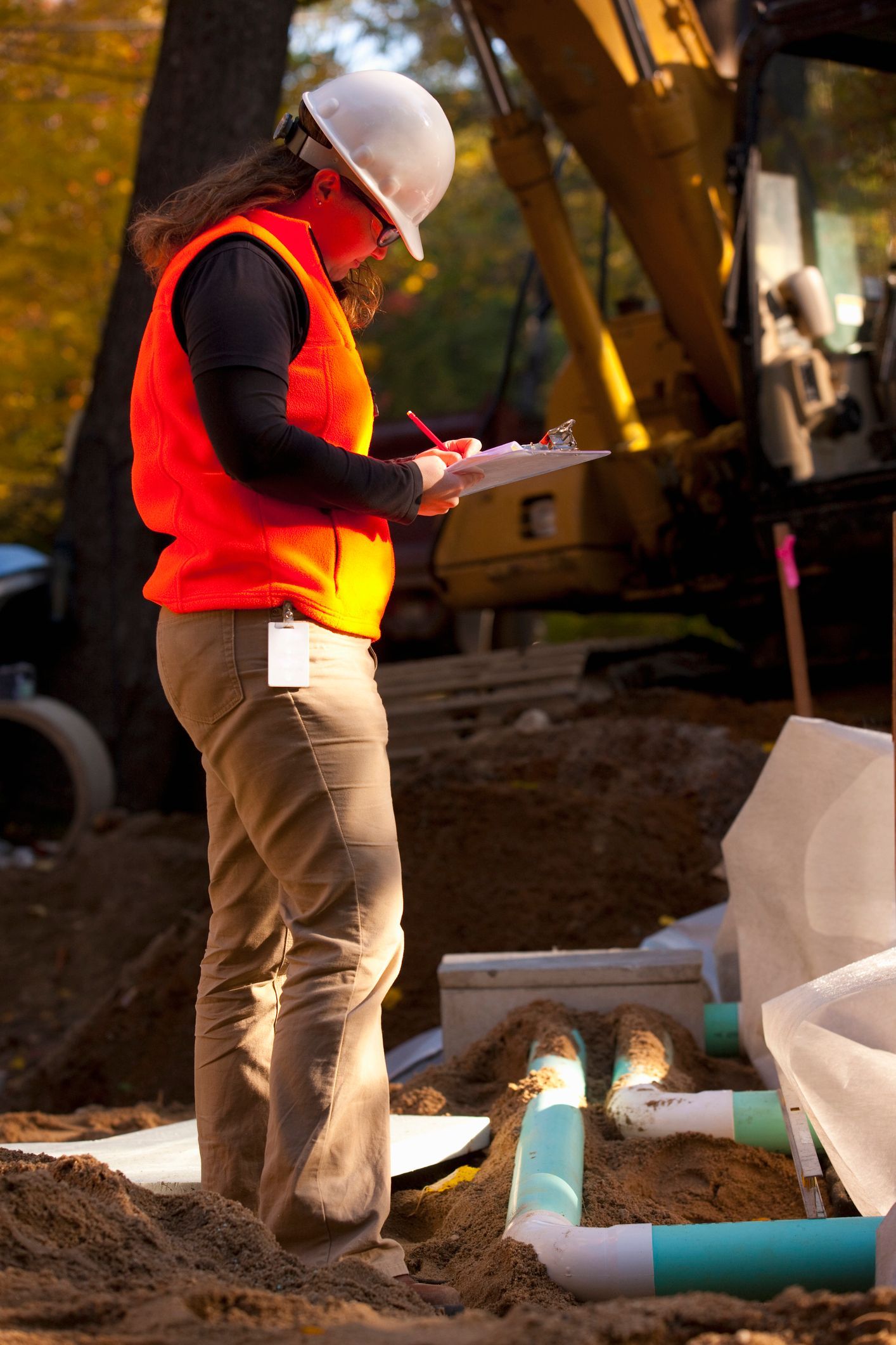Female engineer writing on a clipboard at a construction site