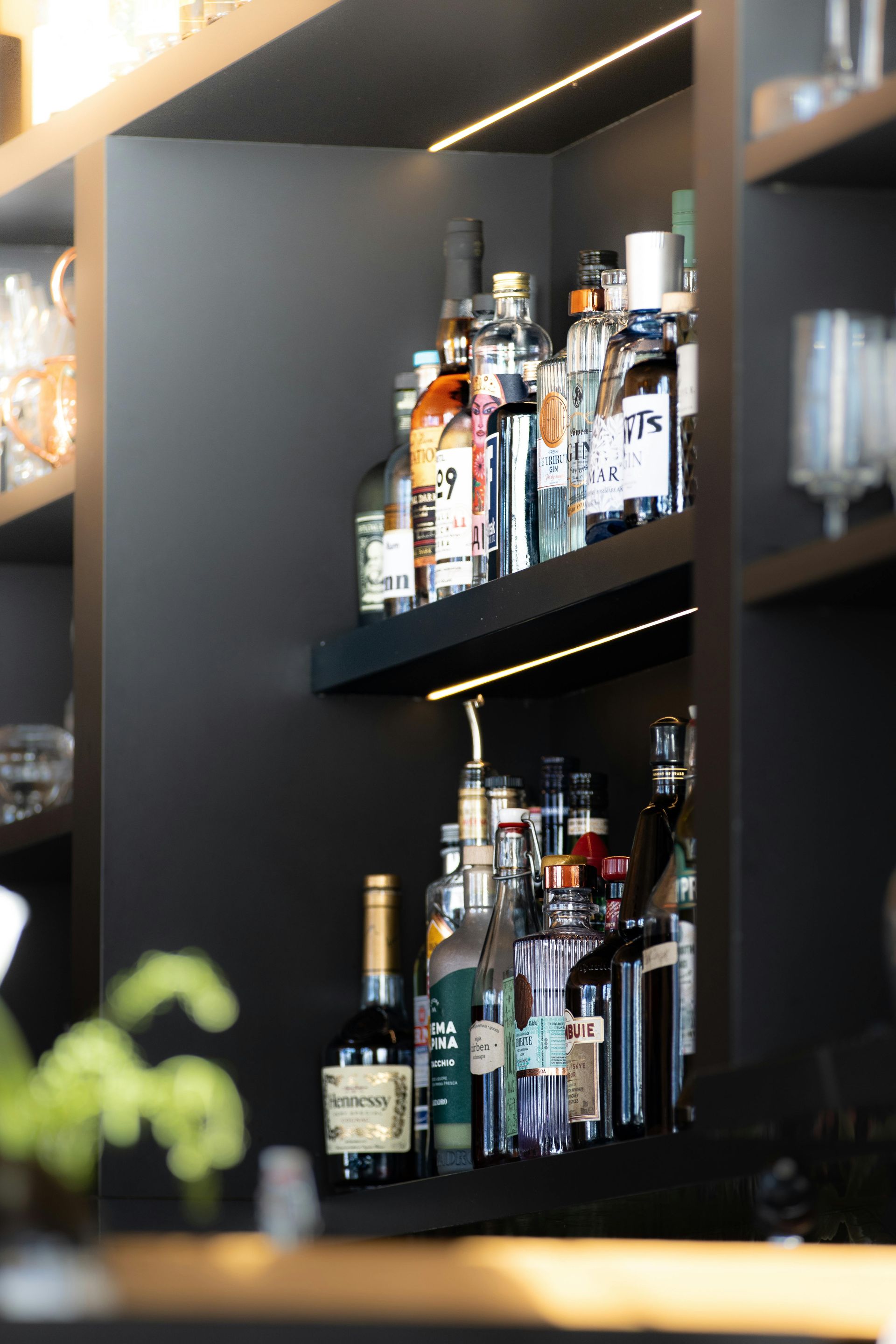 Shelves of assorted liquor bottles displayed in a dimly lit bar or restaurant interior
