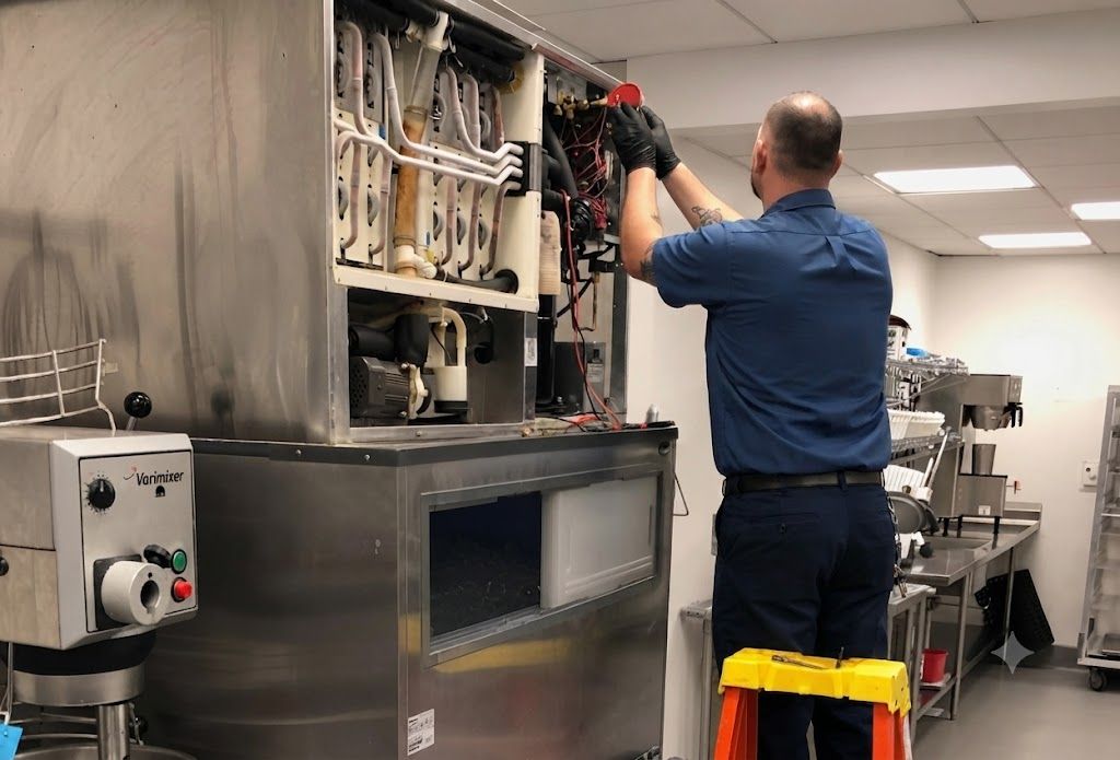 Technician inspecting machinery in a commercial kitchen, standing on a yellow step stool.
