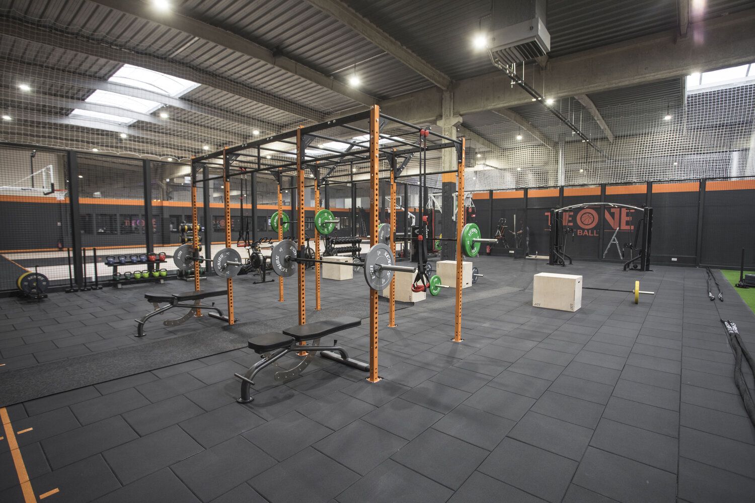 Gym interior with weight racks, weights, benches, and exercise equipment.