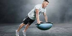 A man is doing push ups on a balance ball.