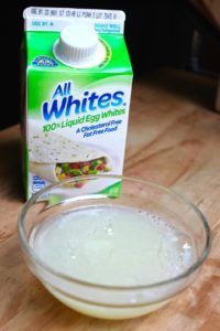 A carton of all whites liquid egg whites next to a bowl of liquid egg whites