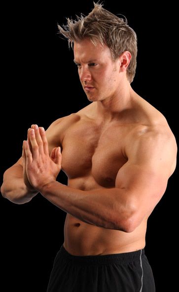 A shirtless man is practicing martial arts with his hands together.