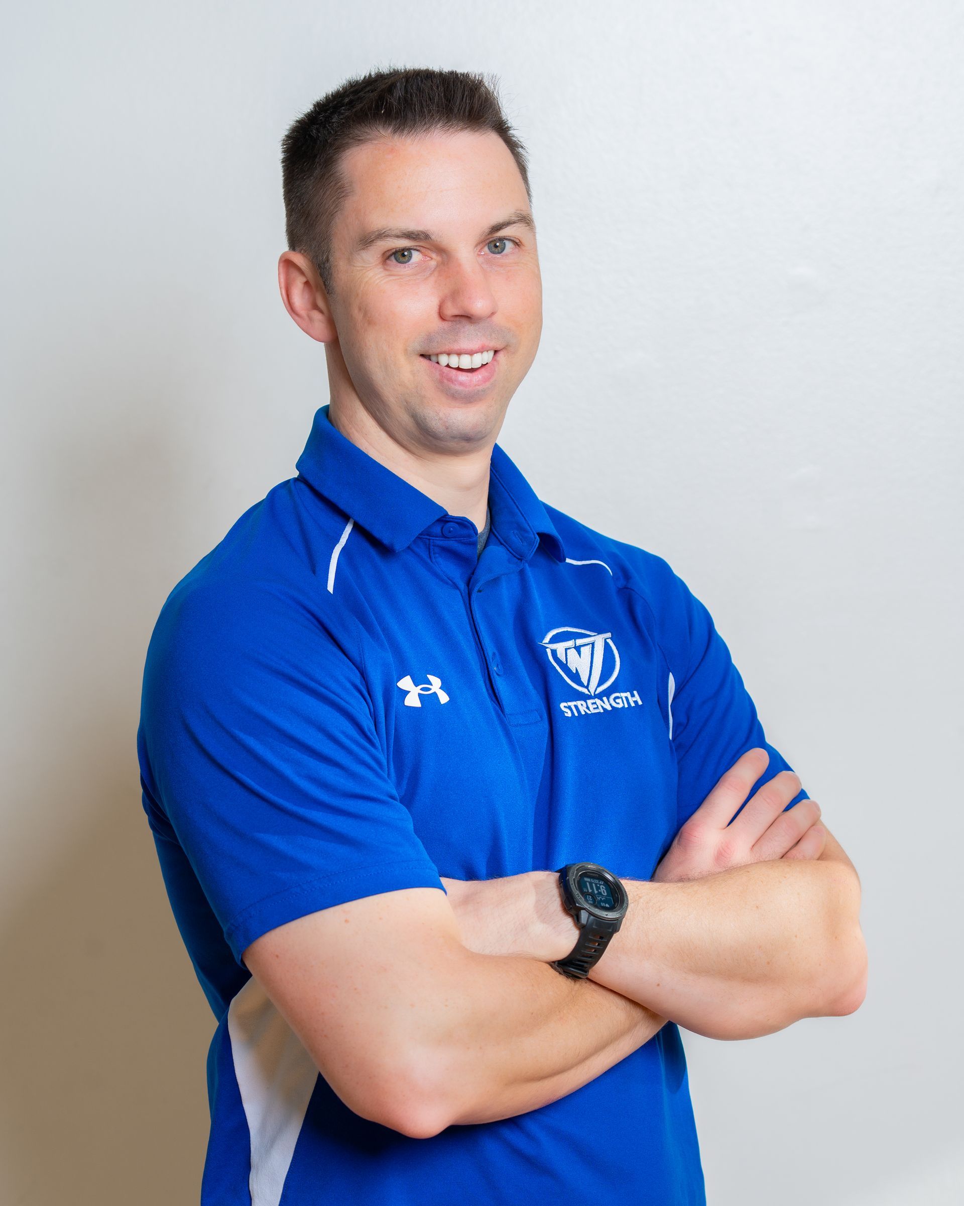 Jesse Schmidt, Strength Coach at TNT Strength in a TNT Strength blue jacket.