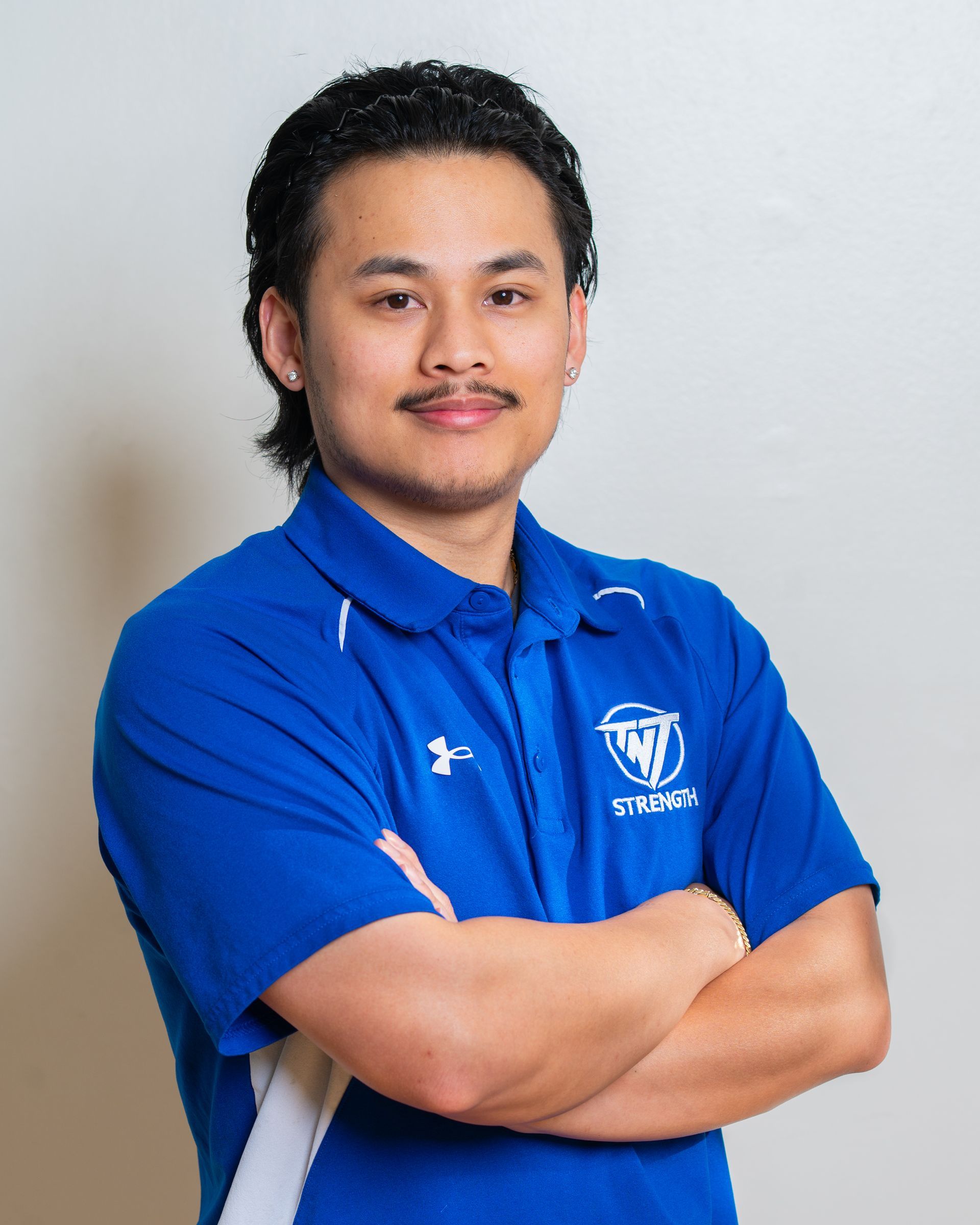 A young man wearing a blue and white polo shirt is smiling for the camera.