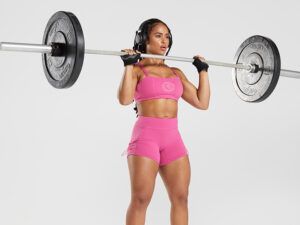 A woman is lifting a barbell over her head.