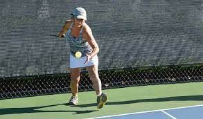 A woman is playing tennis on a tennis court.
