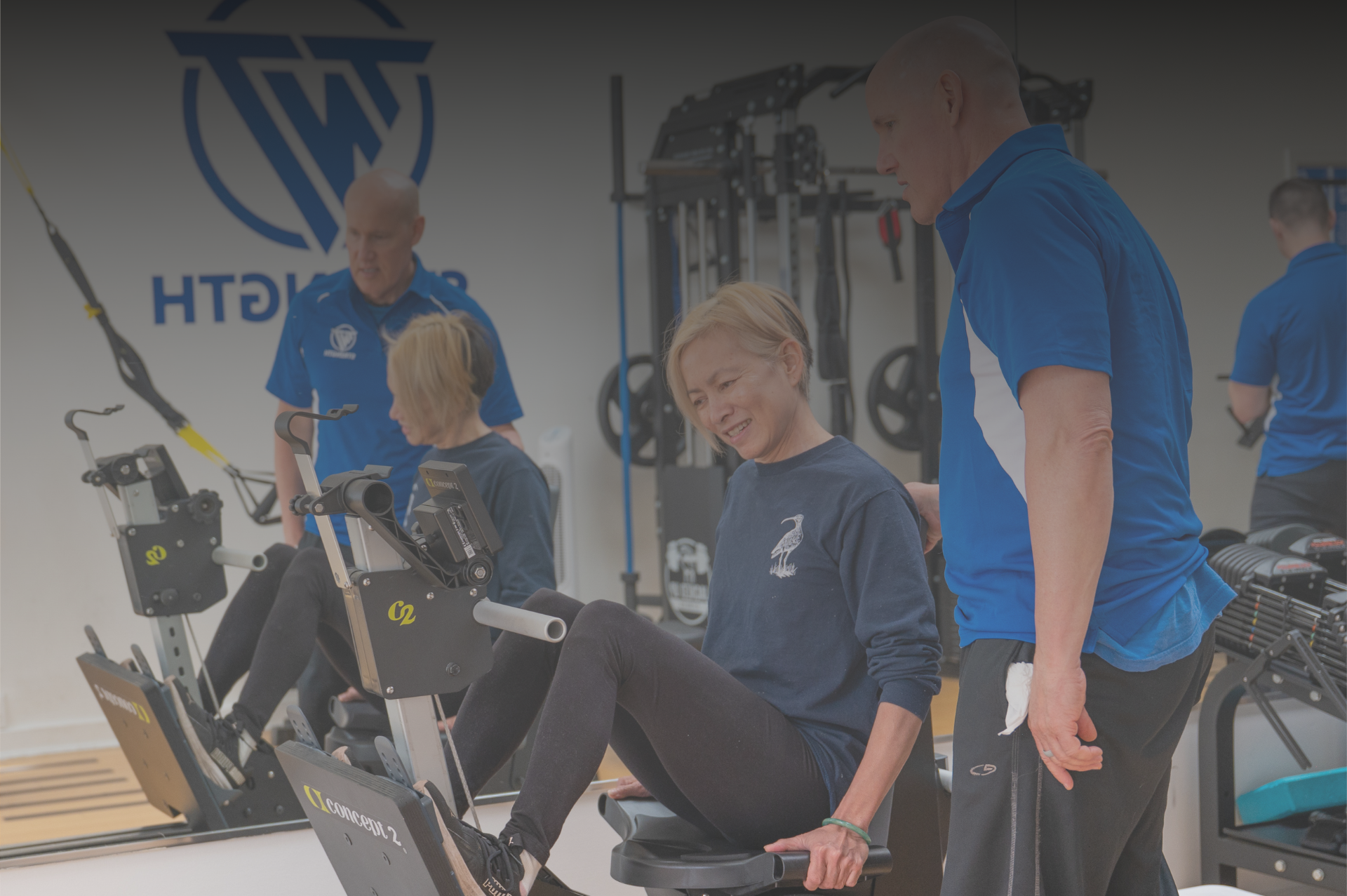 TNT Strength Coaches four in TNT Strength blue jackets standing next to each other.