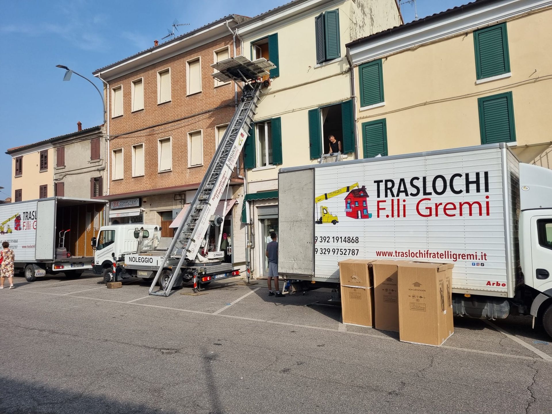 Camion per traslochi e scala davanti a una fila di case durante un trasloco.