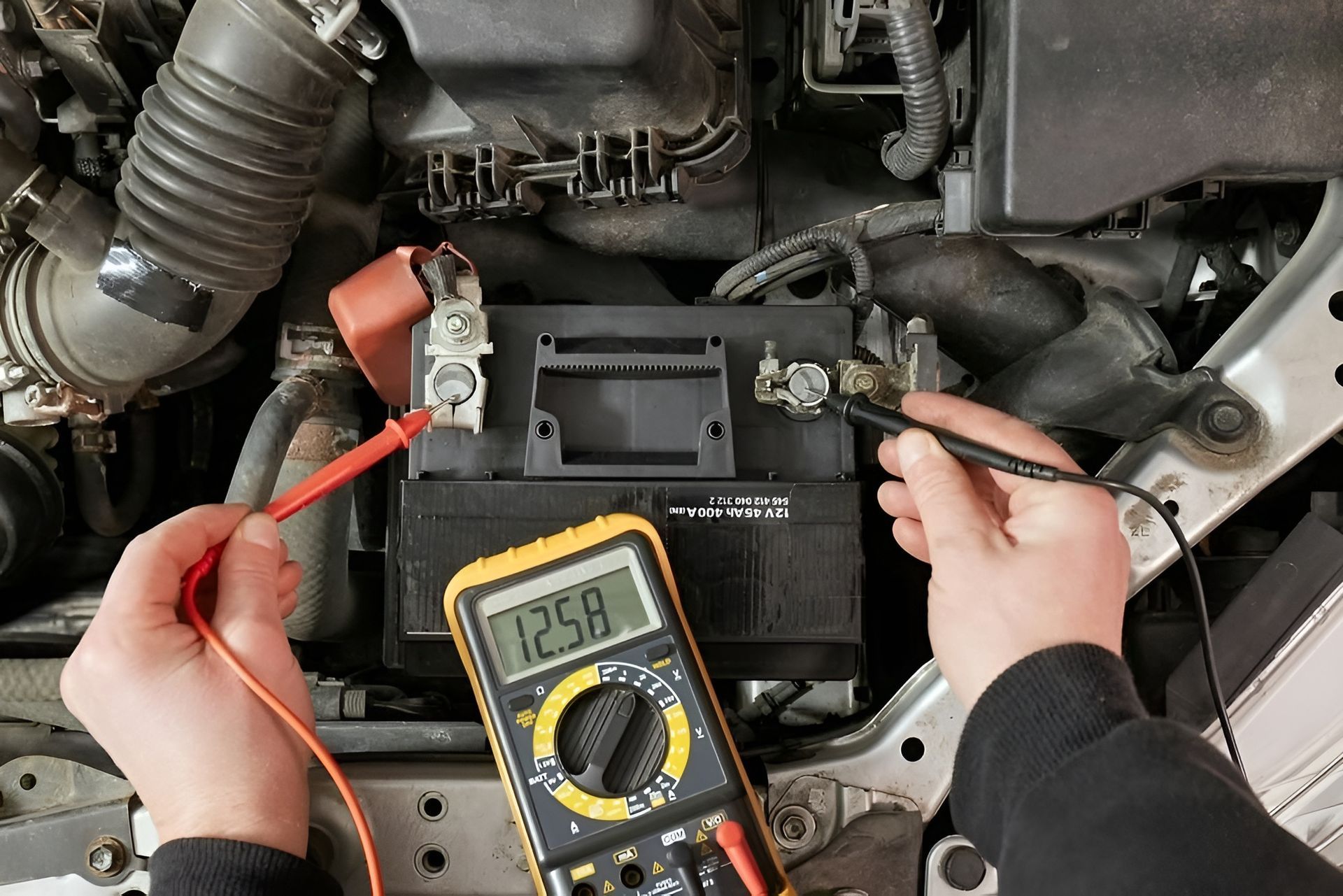 A Person Is Using a Multimeter to Test a Car Battery — Envy Automotive in Gorokan, NSW