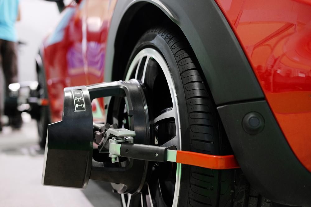 A Red Car Is Being Adjusted by A Machine — Envy Automotive in Gorokan, NSW