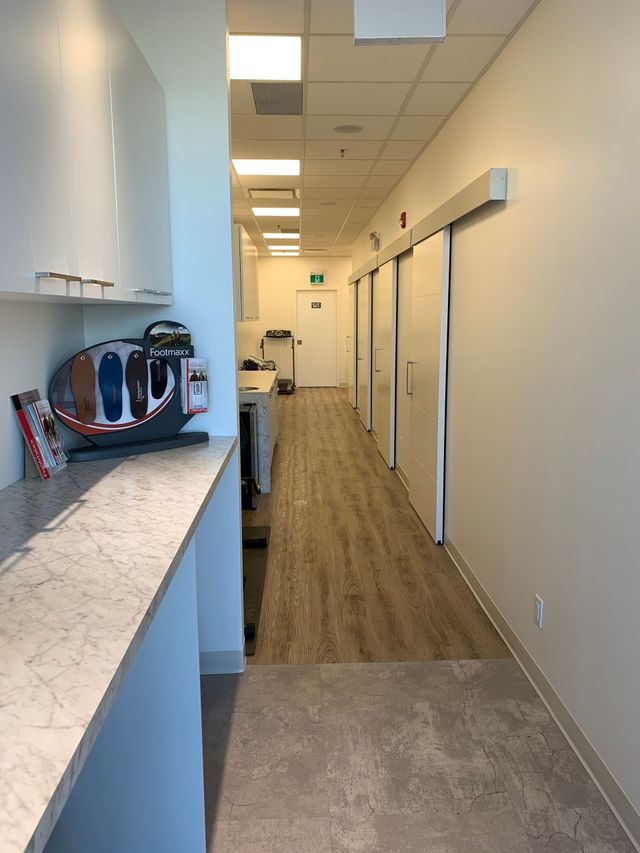 Office hallway with kitchenette counter on the left and closed doors along the right.