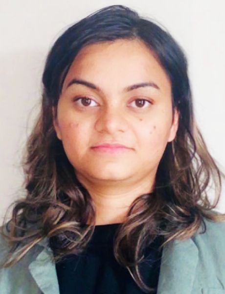 A woman with long hair is wearing a green jacket and a black shirt.