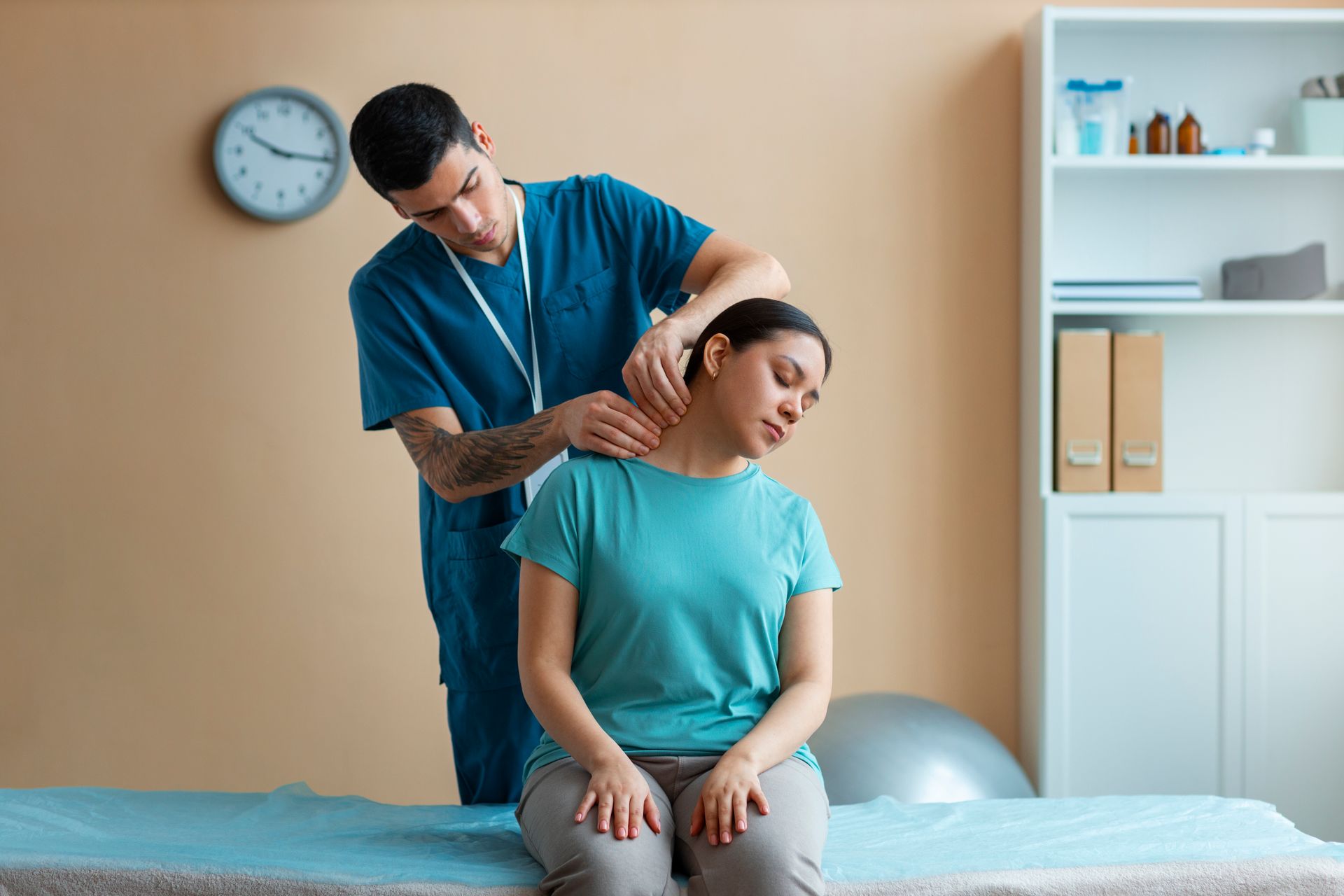 Physical therapist adjusting a patient's neck on a treatment table in a clinic room