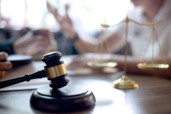 A judge 's gavel and scales of justice are on a table.