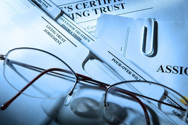 A pair of glasses sits on top of a document that says ' s certified living trust '
