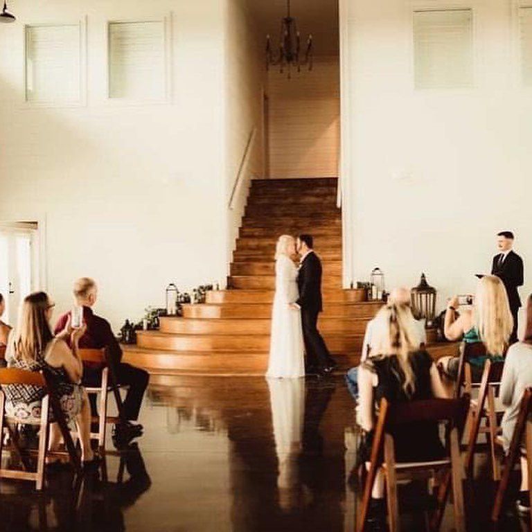 Bride and groom in front of stairs with guests
