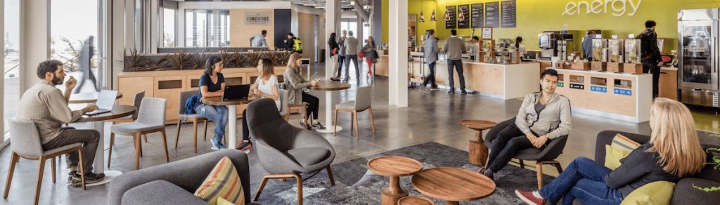 A group of people are sitting at tables in a living room.
