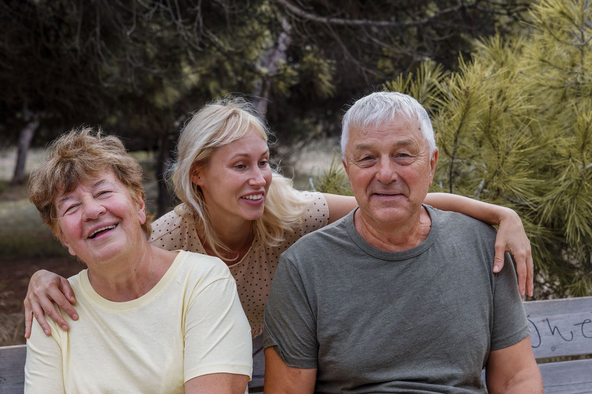 A family is sitting on a bench in a park.