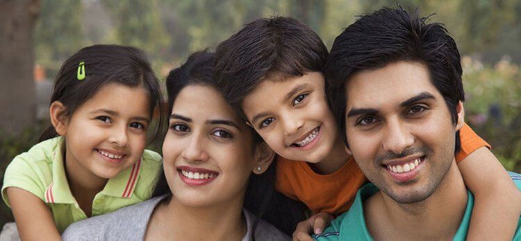 A family is posing for a picture together in a park.
