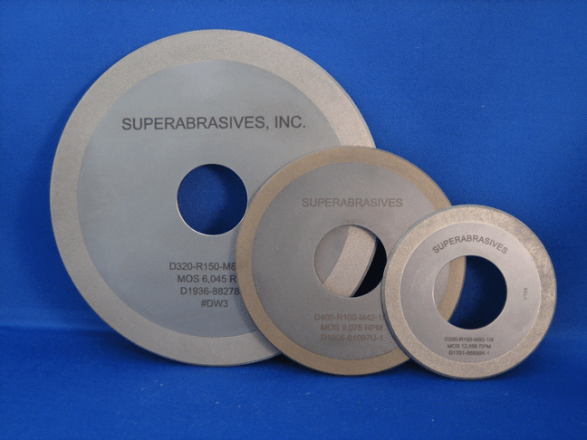 Tres tamaños diferentes de superabrasivos, incluidas ruedas, sobre una superficie azul