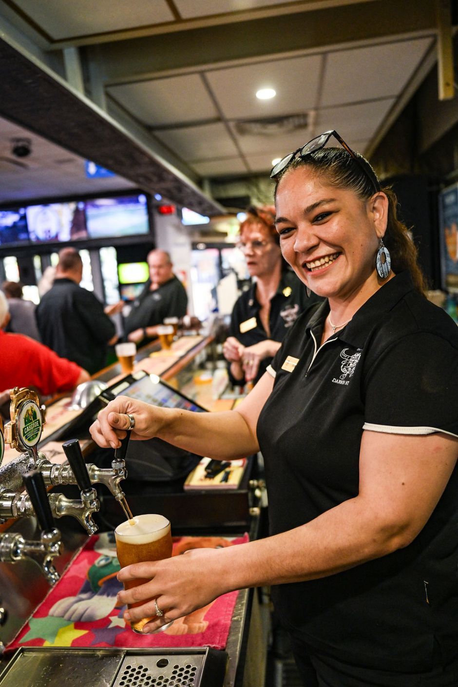 Happy Woman Pouring Cold Beer Into Glass — Pub in Stuart Park, NT