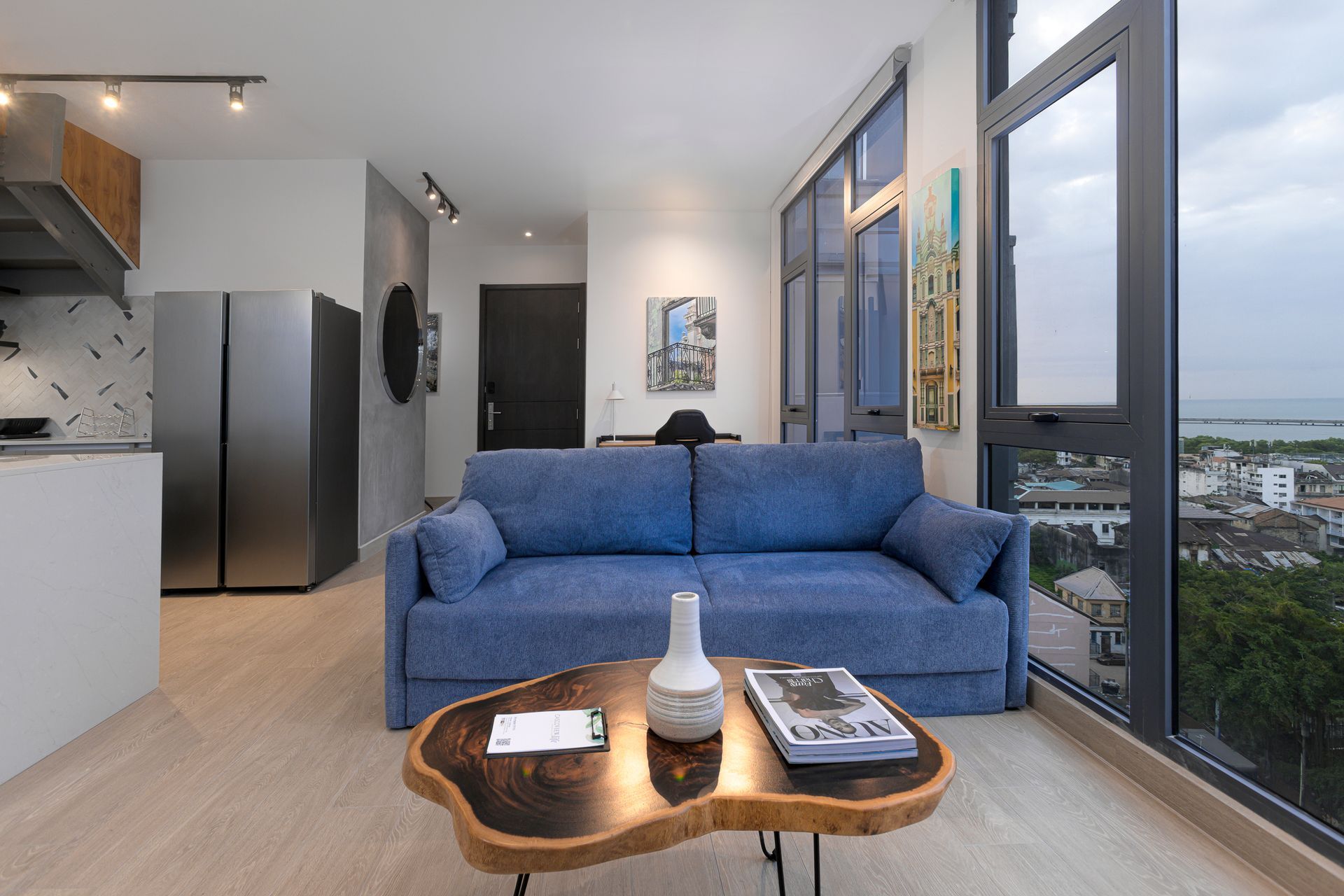Luxury loft living room with blue sofa and panoramic city views towards Casco Viejo in the Casco View building.