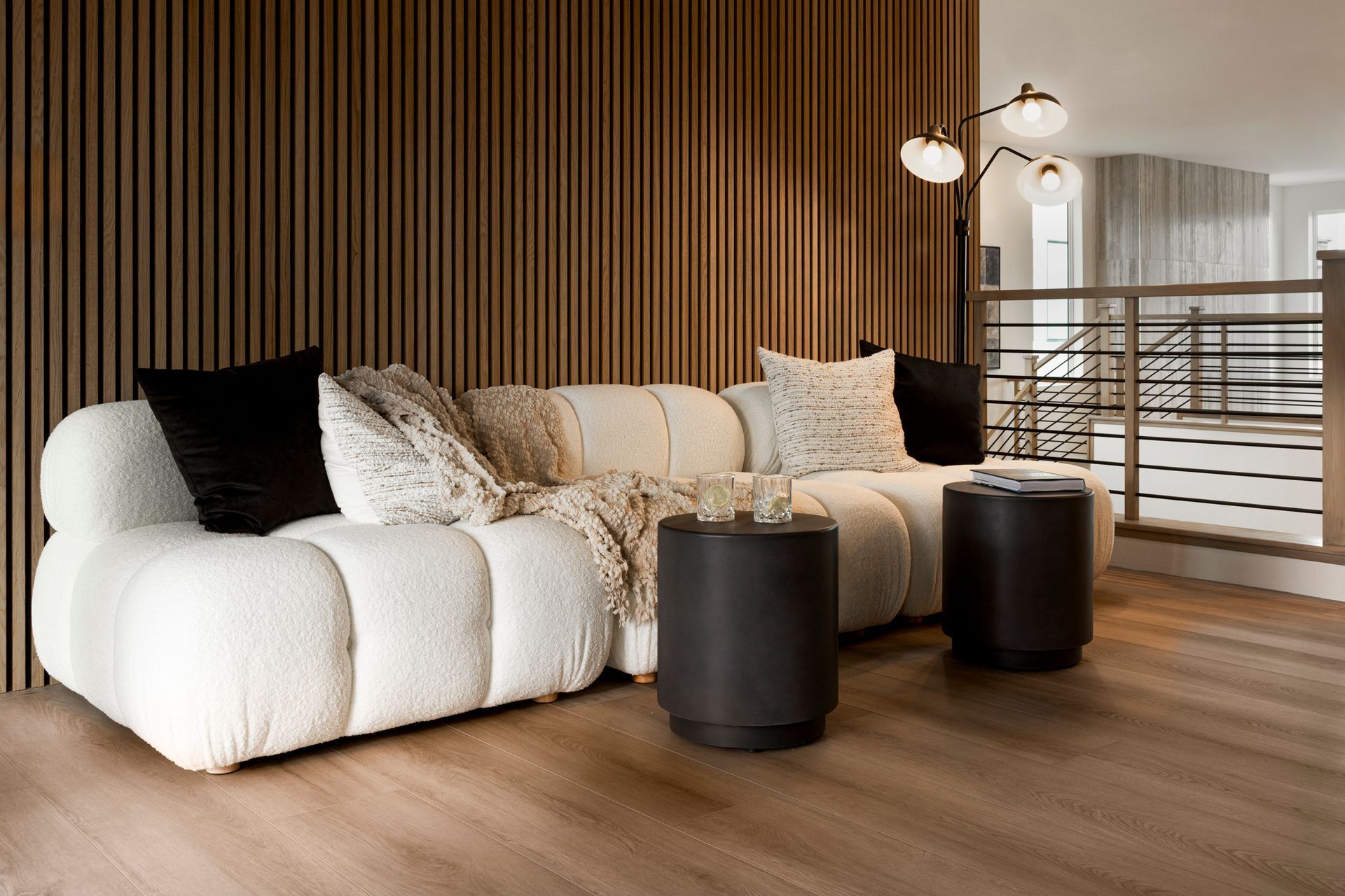 Luxury living room interior in Las Vegas featuring a white bouclé sofa and modern wood wall paneling.