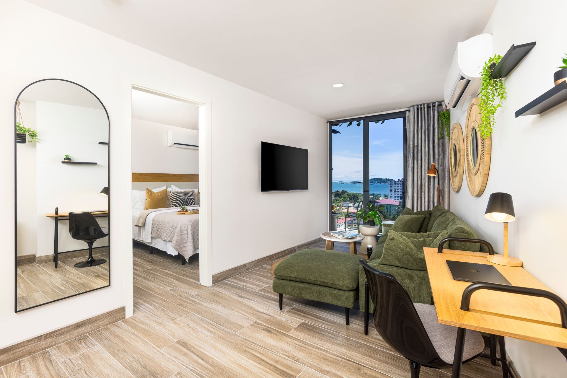 Modern Airbnb living room with industrial-chic decor and panoramic windows in Casco View, Panama City.