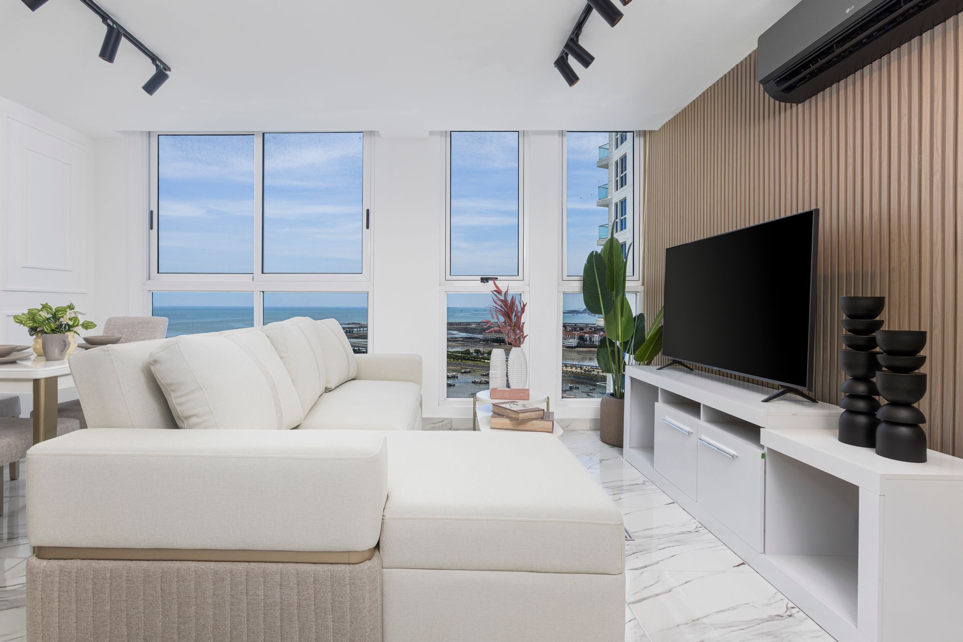 Modern Airbnb living room interior with panoramic city views in The Sands building, Panama City.