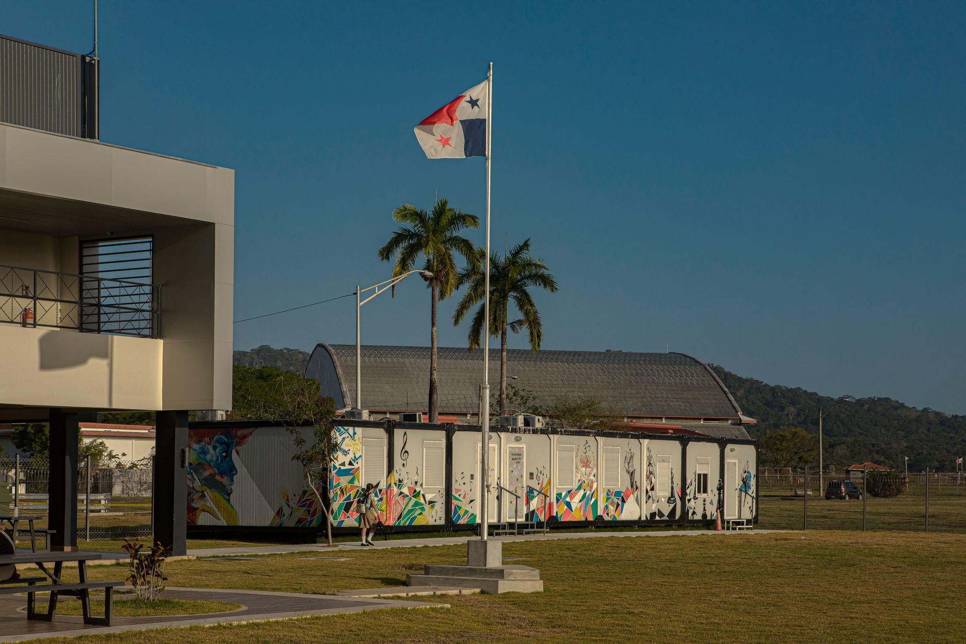 Panamanian flag waving in front of the modern modular buildings at Howard Academy campus.
