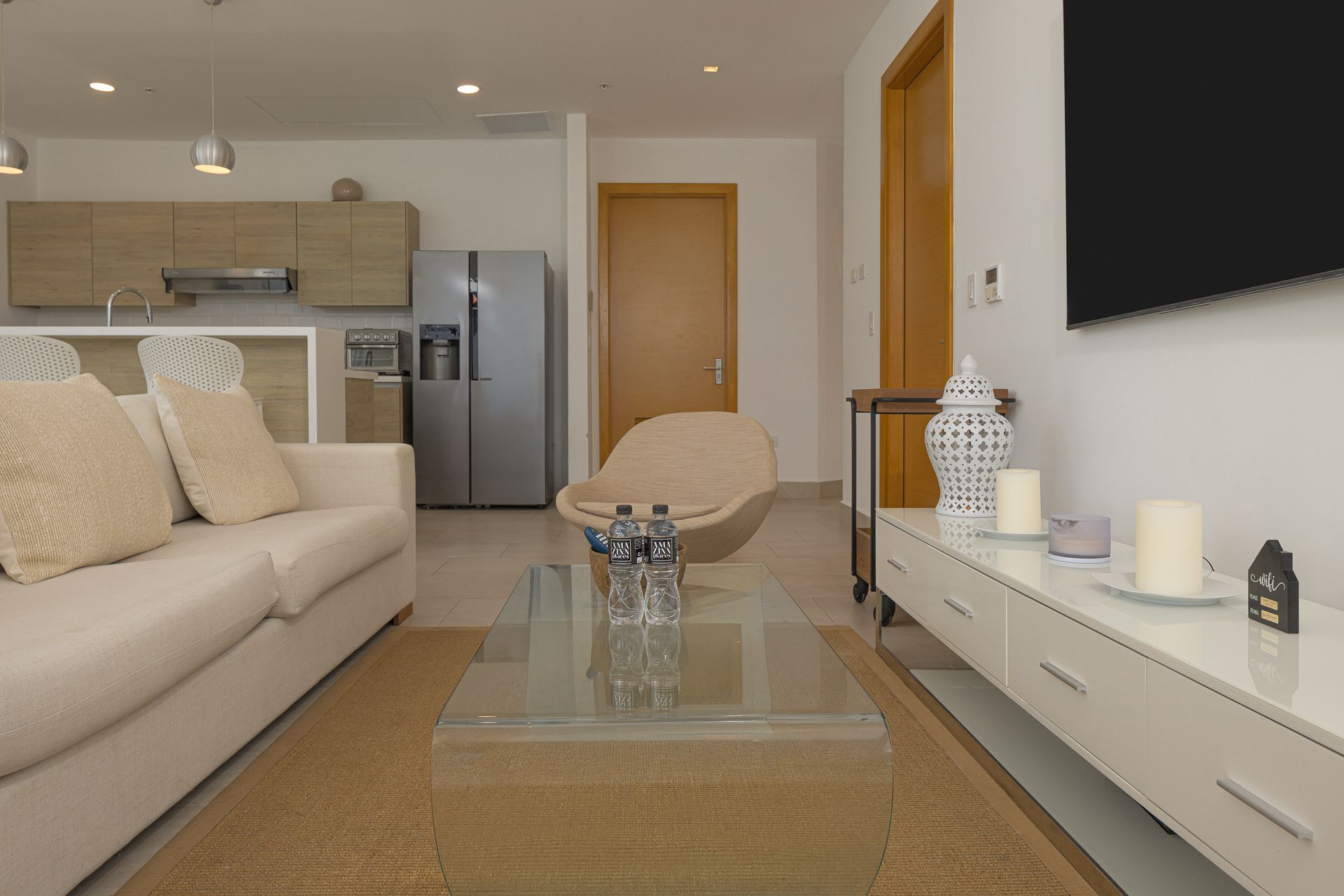 Open-concept living room and integrated kitchen in three-bedroom Playa Escondida apartment on Amazinn Places, Panamá