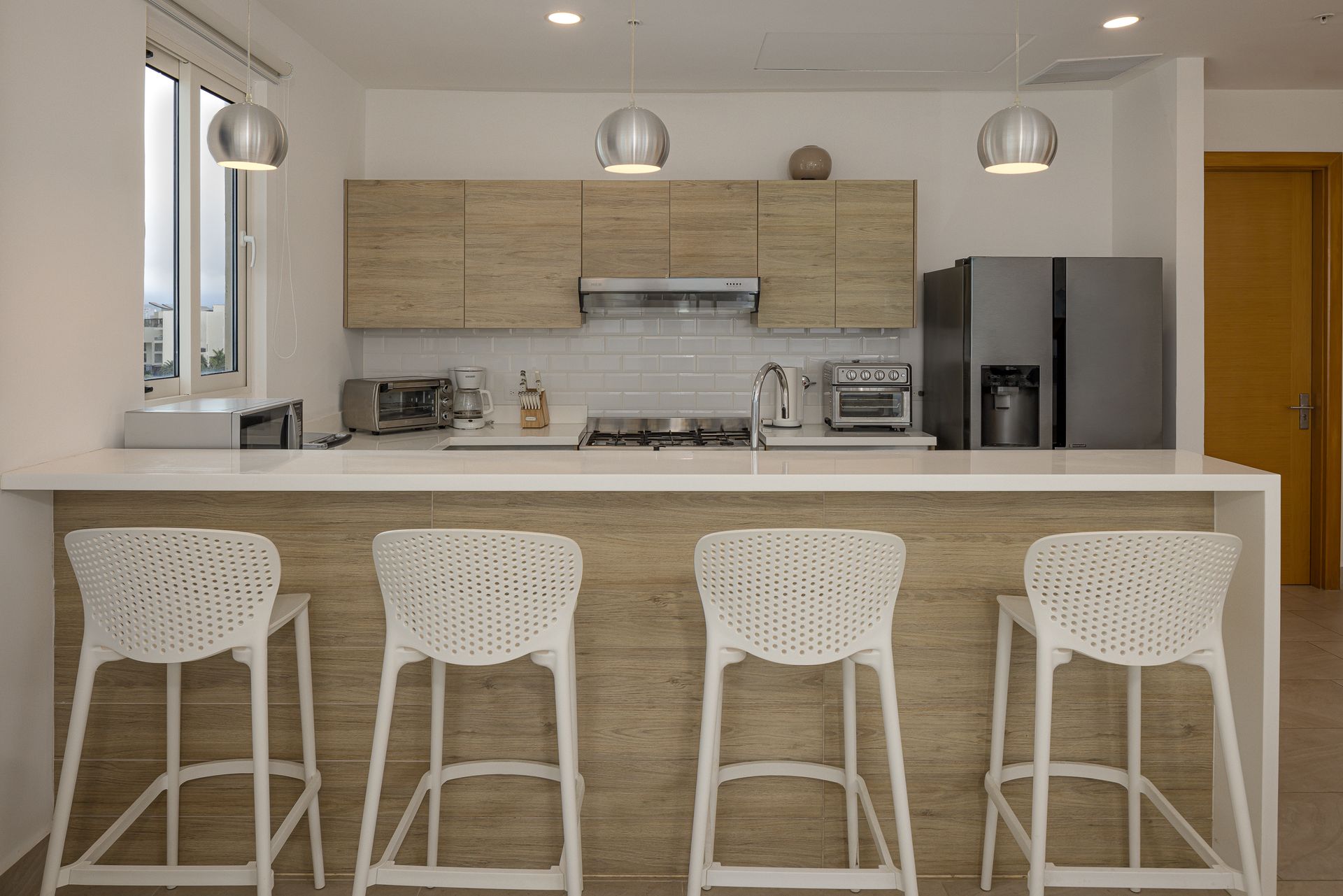 Modern kitchen with breakfast bar at Playa Escondida apartment listed on Amazinn Places, Panamá