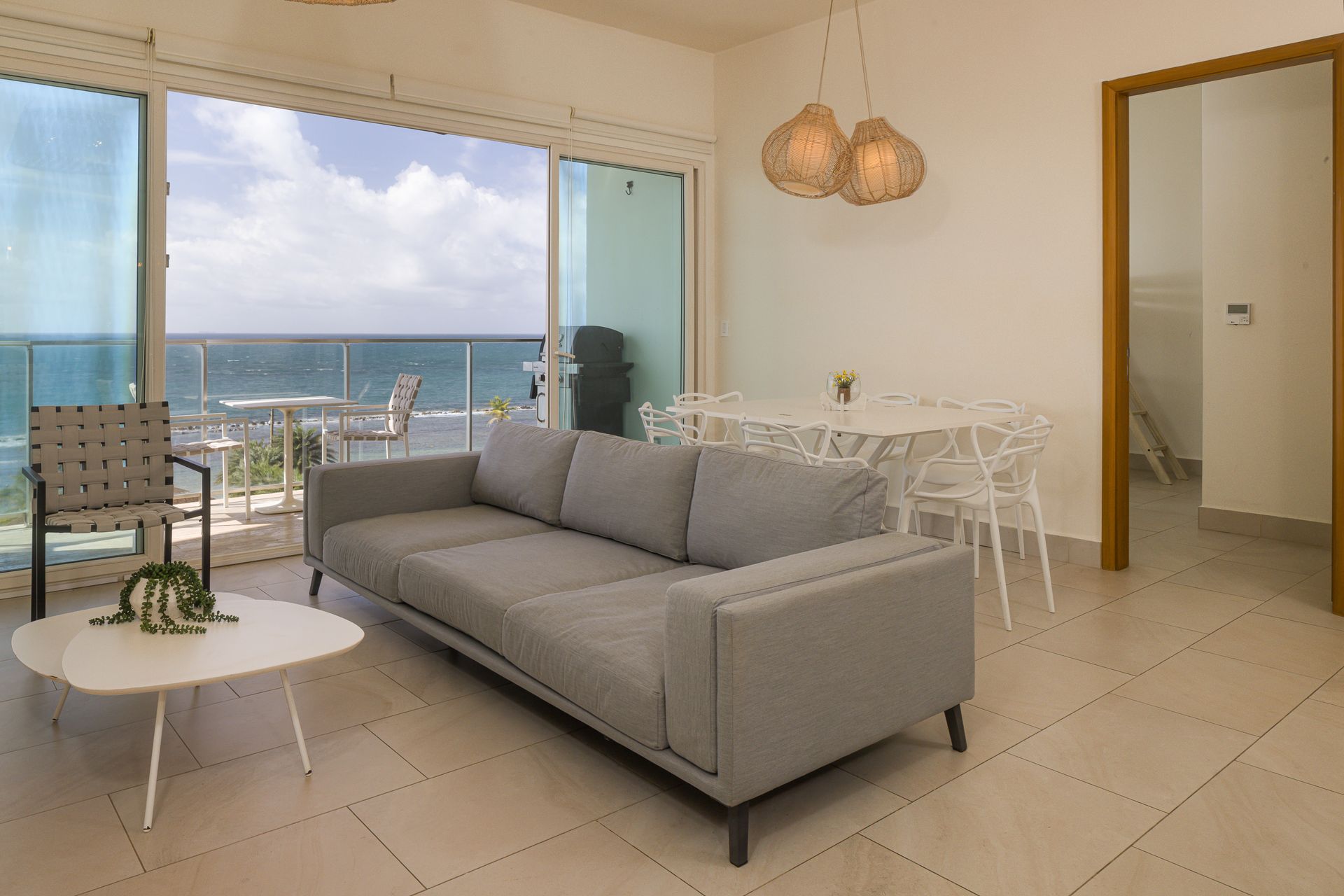 Oceanfront Airbnb living room with gray sofa and balcony view at Playa Escondida Resort, Panama
