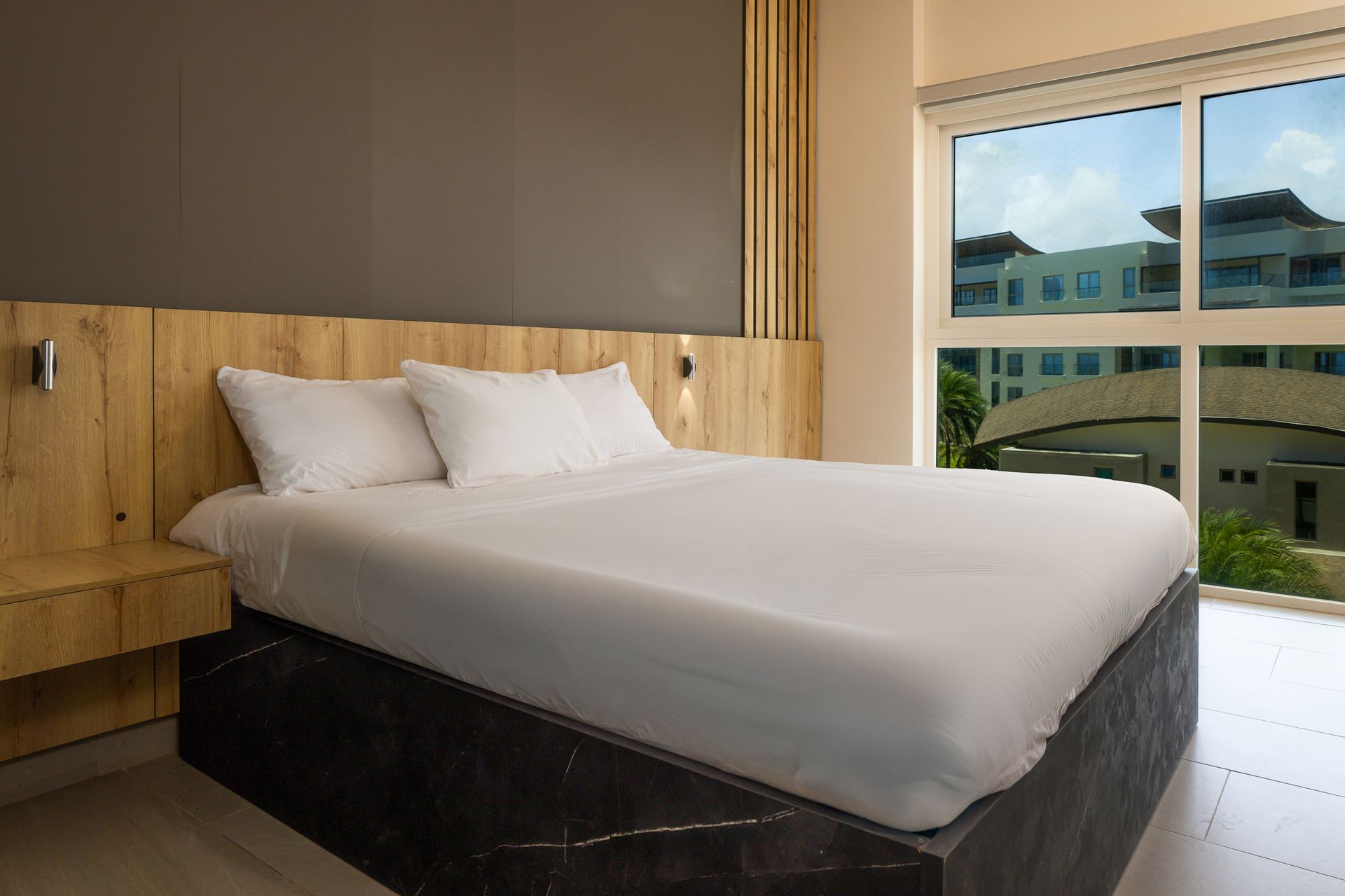 Master bedroom with wooden headboard and resort view at Playa Escondida, Caribbean Panama