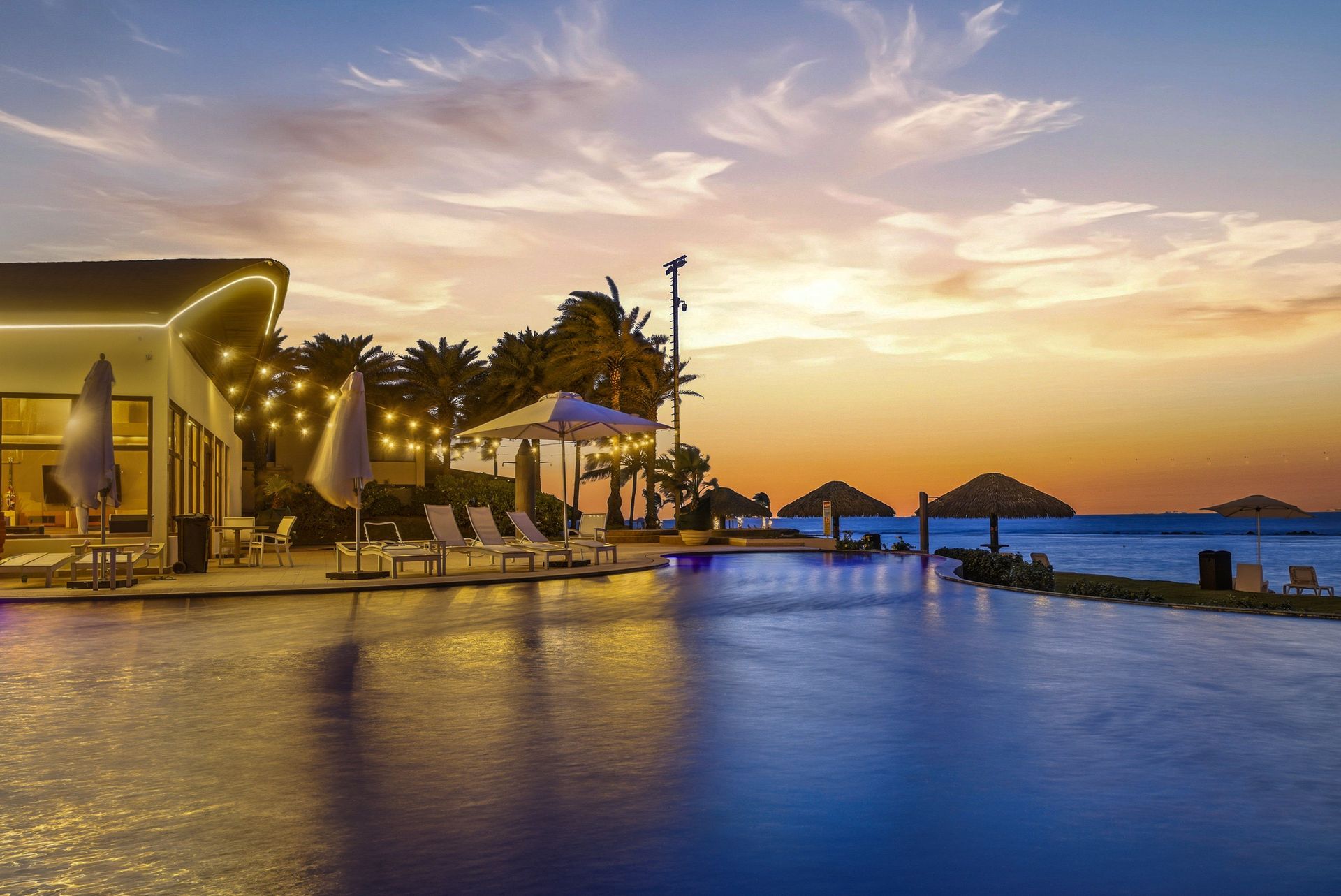 Infinity pool with string lights at sunset, Playa Escondida Resort, Caribbean Panama