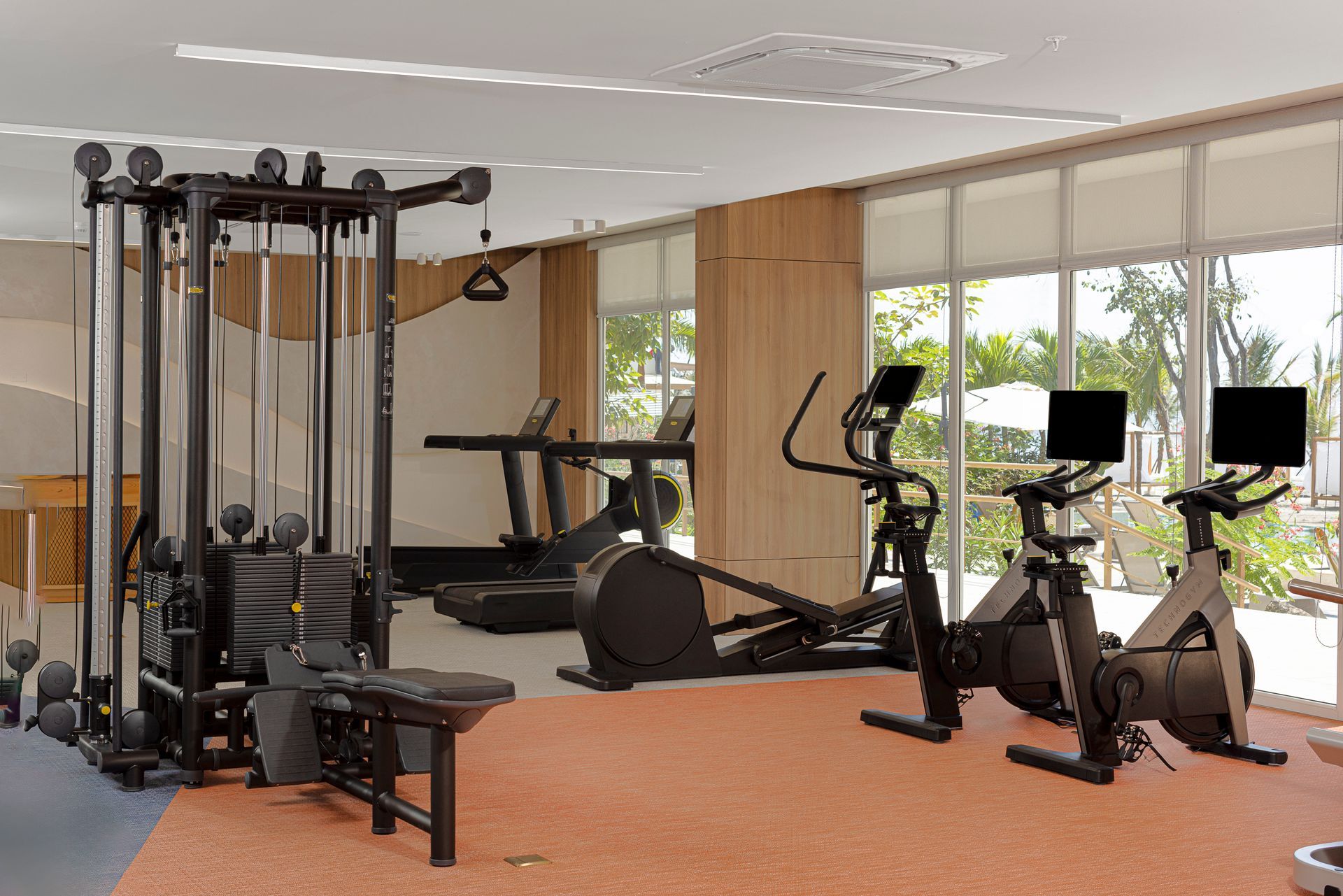Modern hotel gym with treadmills and panoramic ocean views at Radisson Riviera Pacifica, Panama.