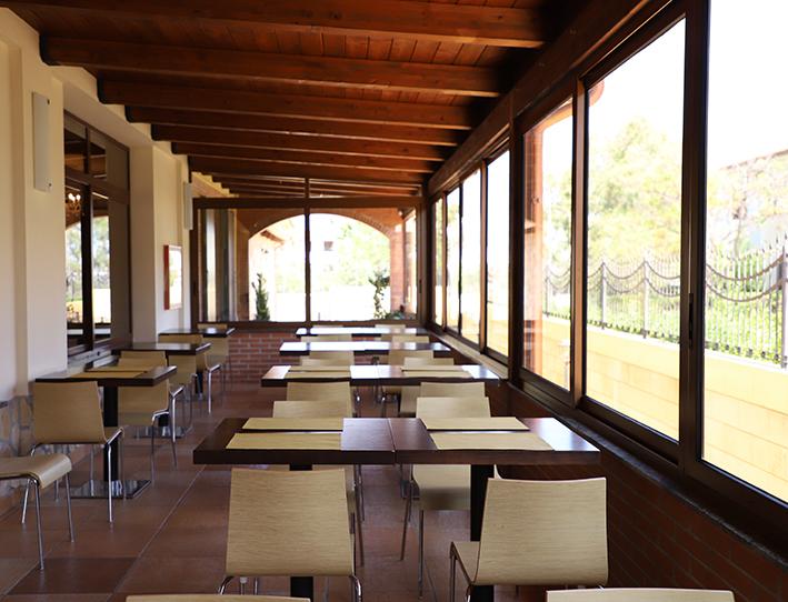 Un ristorante con tavoli e sedie e tante finestre